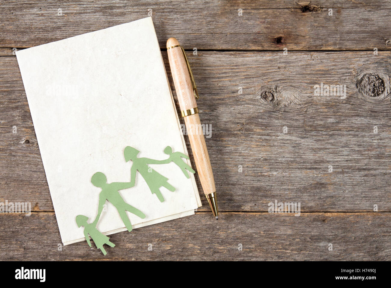 Paper figures of the family on a paper sheet with a pen Stock Photo