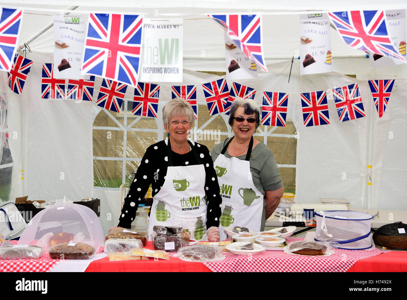 Two members of the WI (Women's Institute) on their cake stall at a local outdoor festival, Four Marks, near Alton, Hampshire, UK. Stock Photo