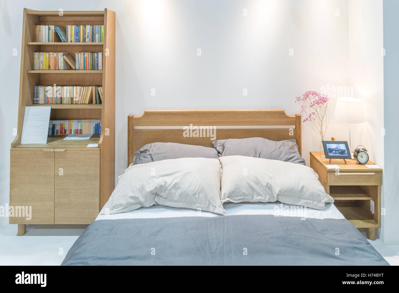 Modern bedroom interior with wooden bed and bookshelf in bedroom