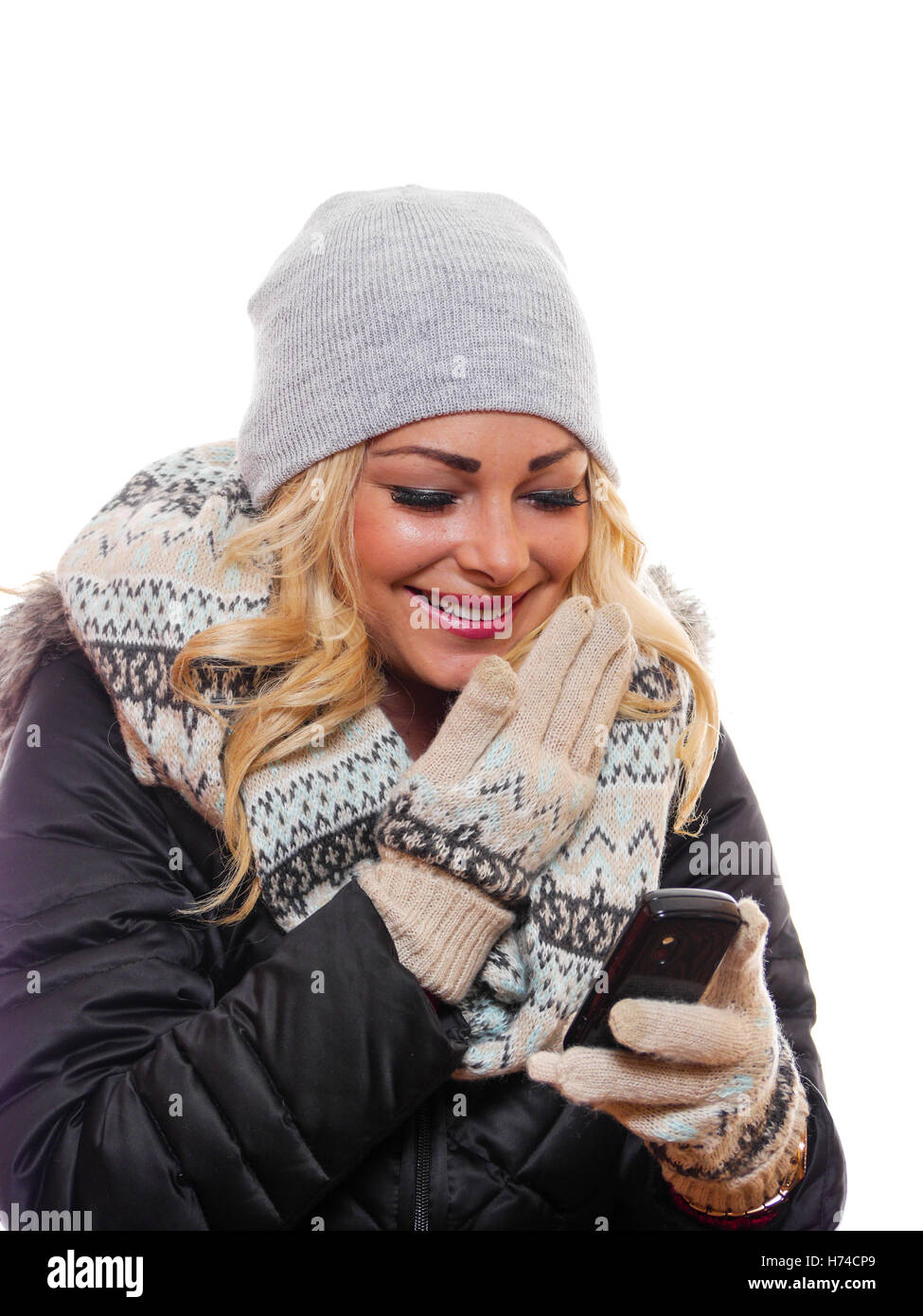 A attractive blond woman is laughing while looking at her cell phone. Stock Photo