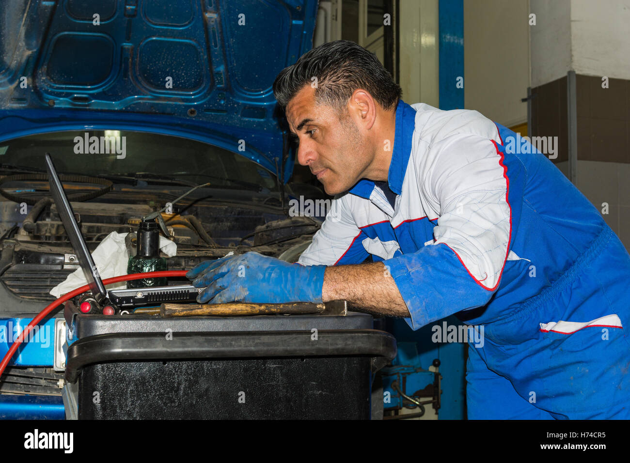 Car mechanic fixing an engine in his garage. copy space Stock Photo - Alamy