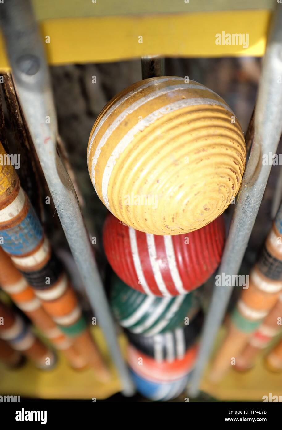 Close-up of old croquet set balls and equipment stored vertically in its antiquated holder. Stock Photo