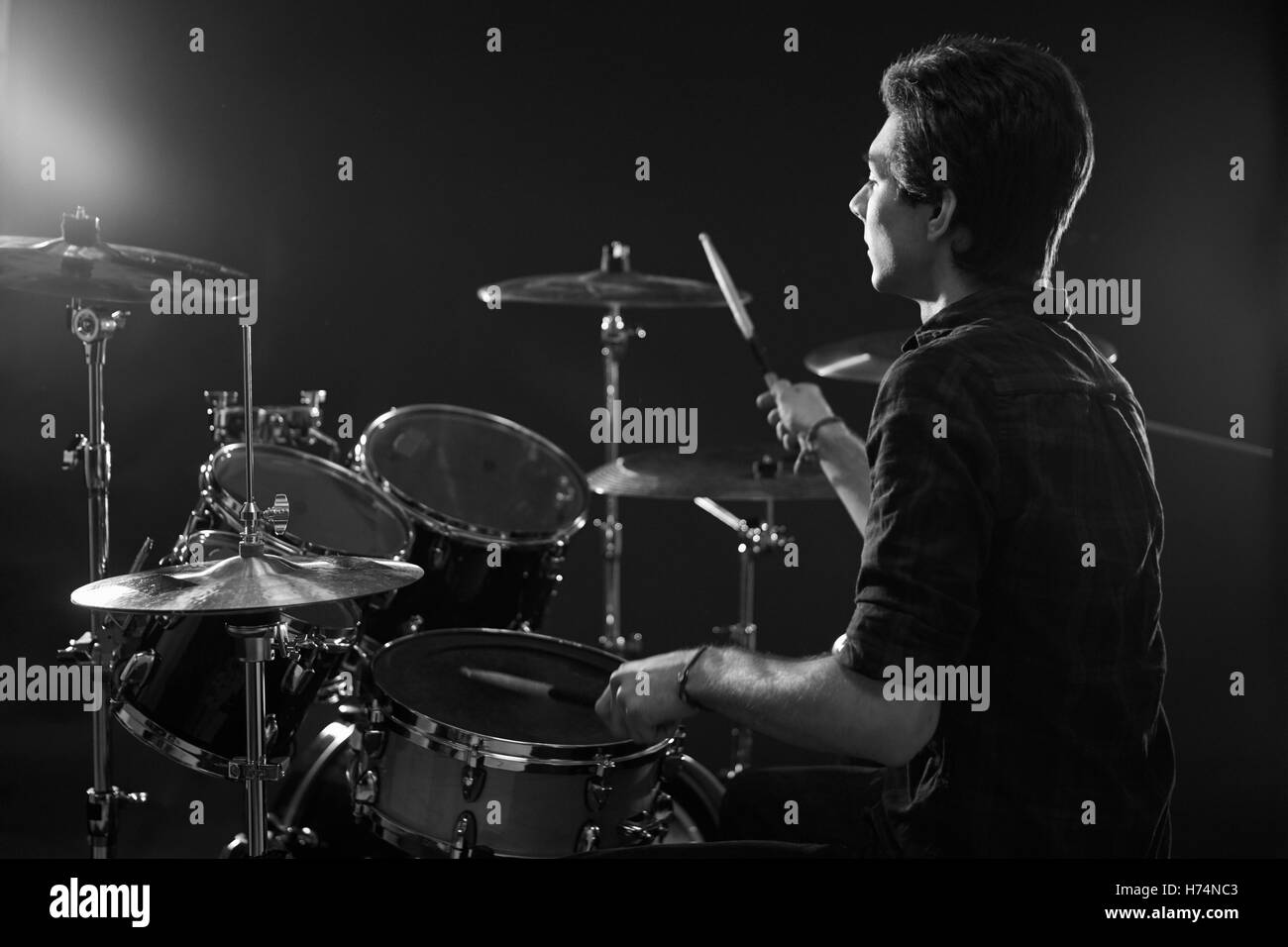 Black And White Shot Of Drummer Playing Drum Kit In Studio Stock Photo