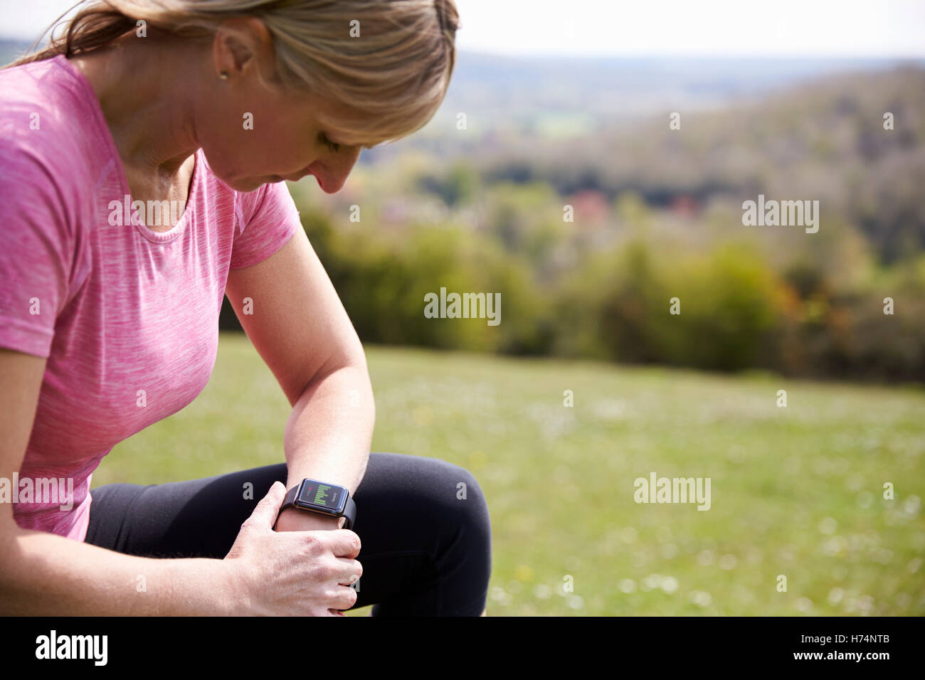 Mature Woman Checking Activity Tracker Whilst On Run Stock Photo