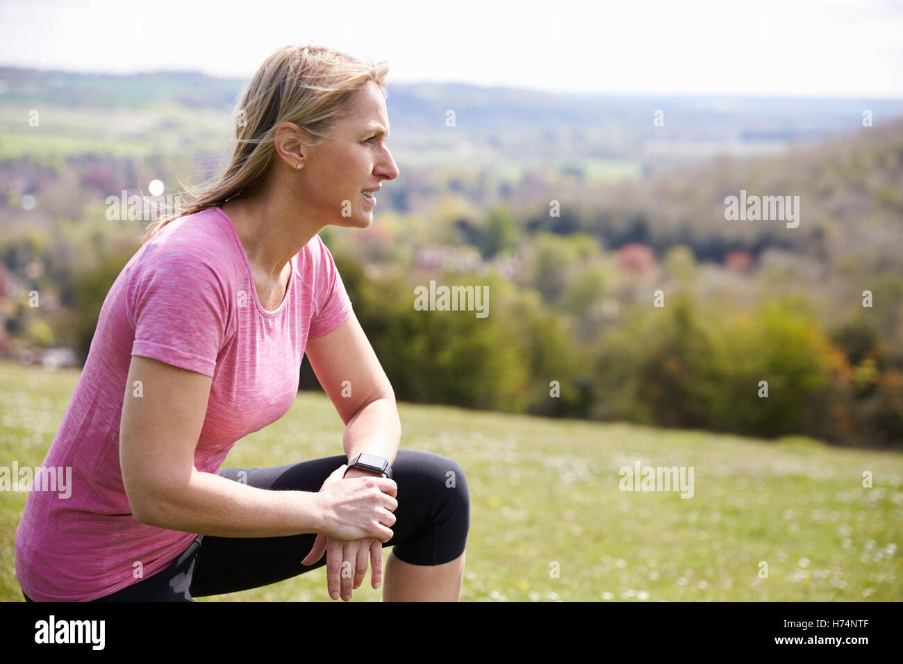 Mature Woman Checking Activity Tracker Whilst On Run Stock Photo