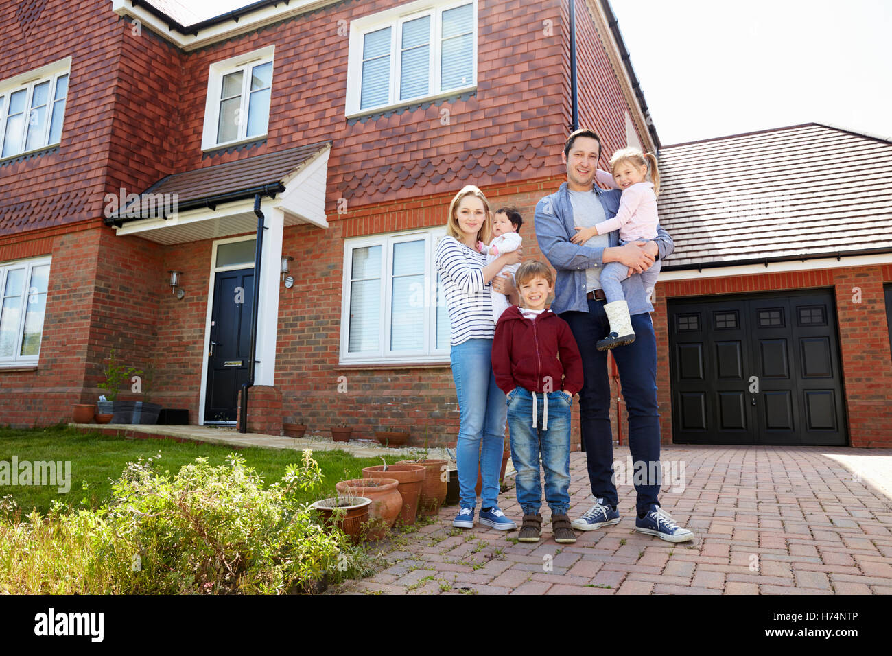 Portrait Of Young Family Standing Outside New Home Stock Photo - Alamy