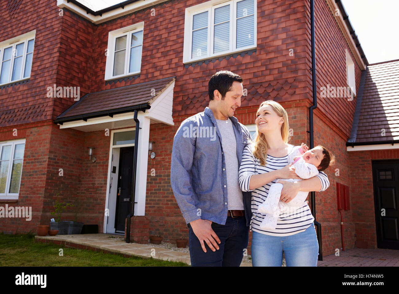 Young Family Standing Outside New Home Stock Photo - Alamy
