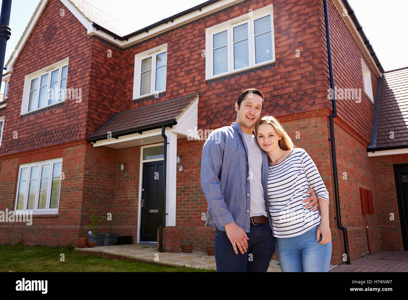 Portrait Of Young Couple Standing Outside New Home Stock Photo - Alamy