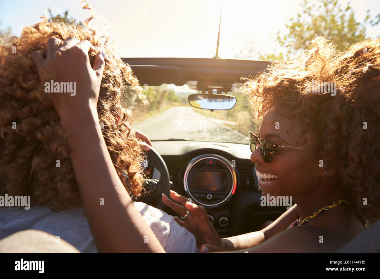 Woman embraces her partner as he drives, close up, Ibiza Stock Photo