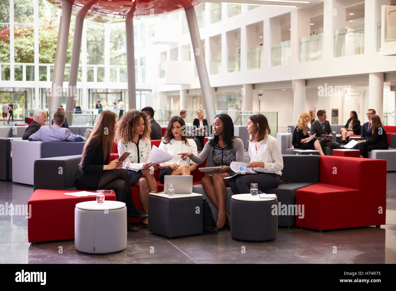 Businesswomen Meeting In Busy Lobby Of Modern Office Stock Photo - Alamy