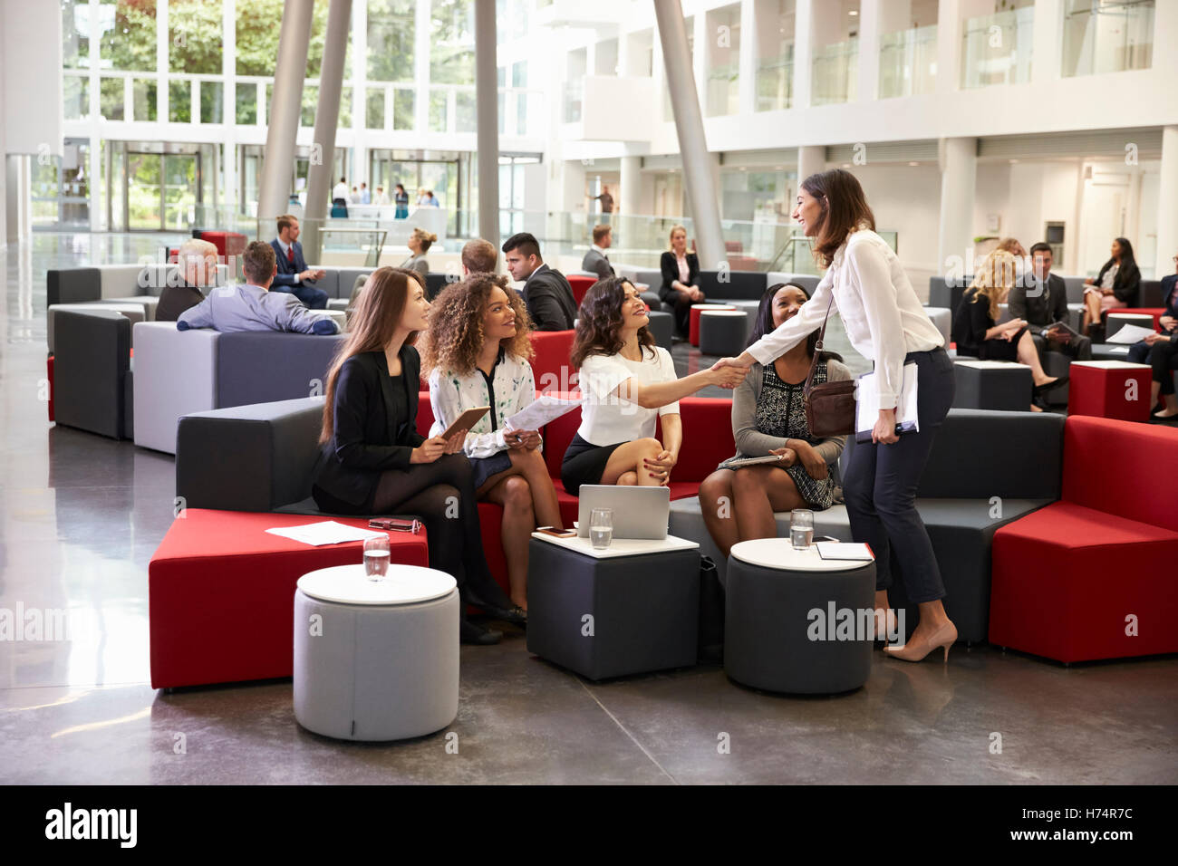 Businesswomen Meeting In Busy Lobby Of Modern Office Stock Photo - Alamy