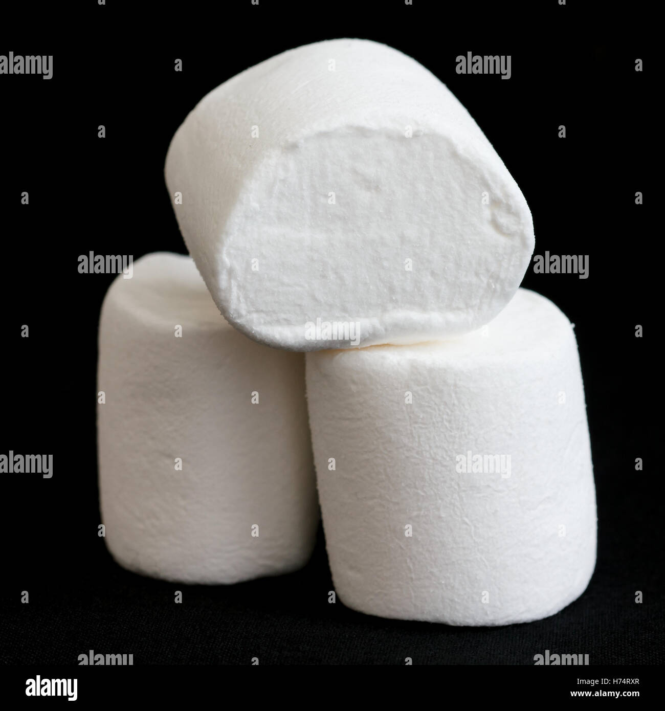 Three marshmallows stacked and isolated on black Stock Photo Alamy