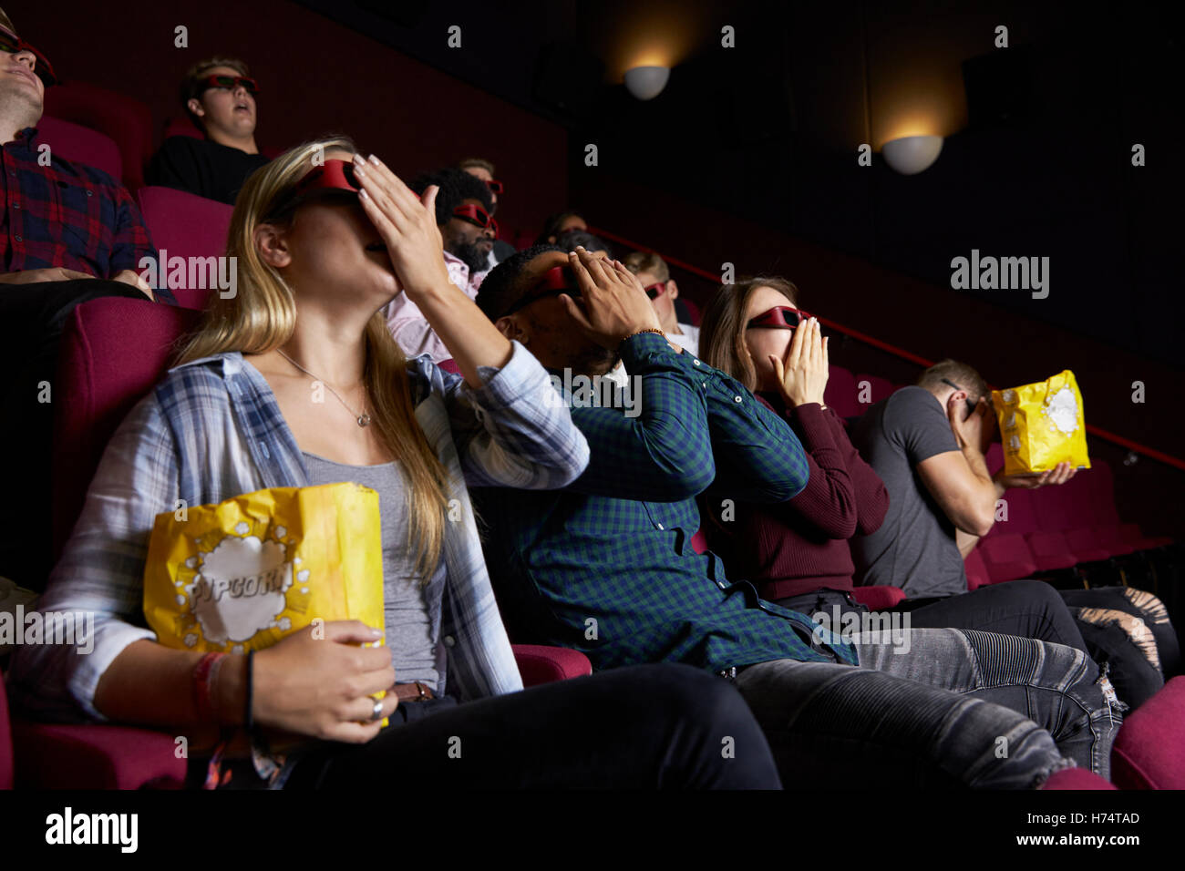 Couple In Cinema Wearing 3D Glasses Watching Horror Film Stock Photo