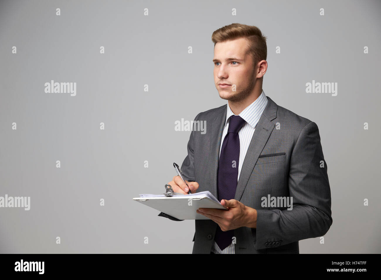 Studio Portrait Of Businessman Writing On Clipboard Stock Photo - Alamy