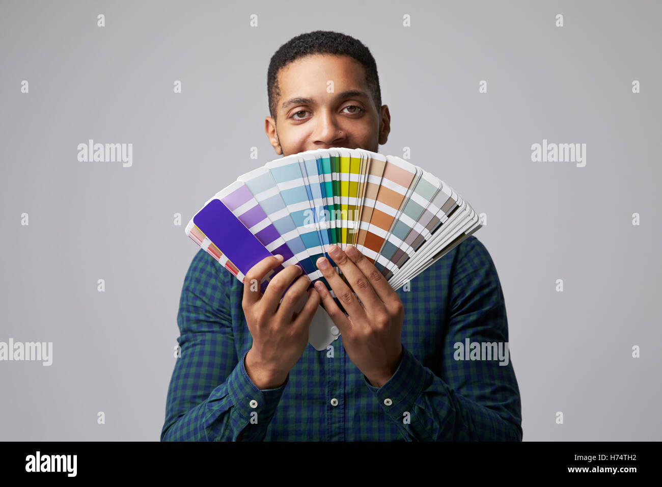 Studio Portrait Of Graphic Designer With Color Swatches Stock Photo