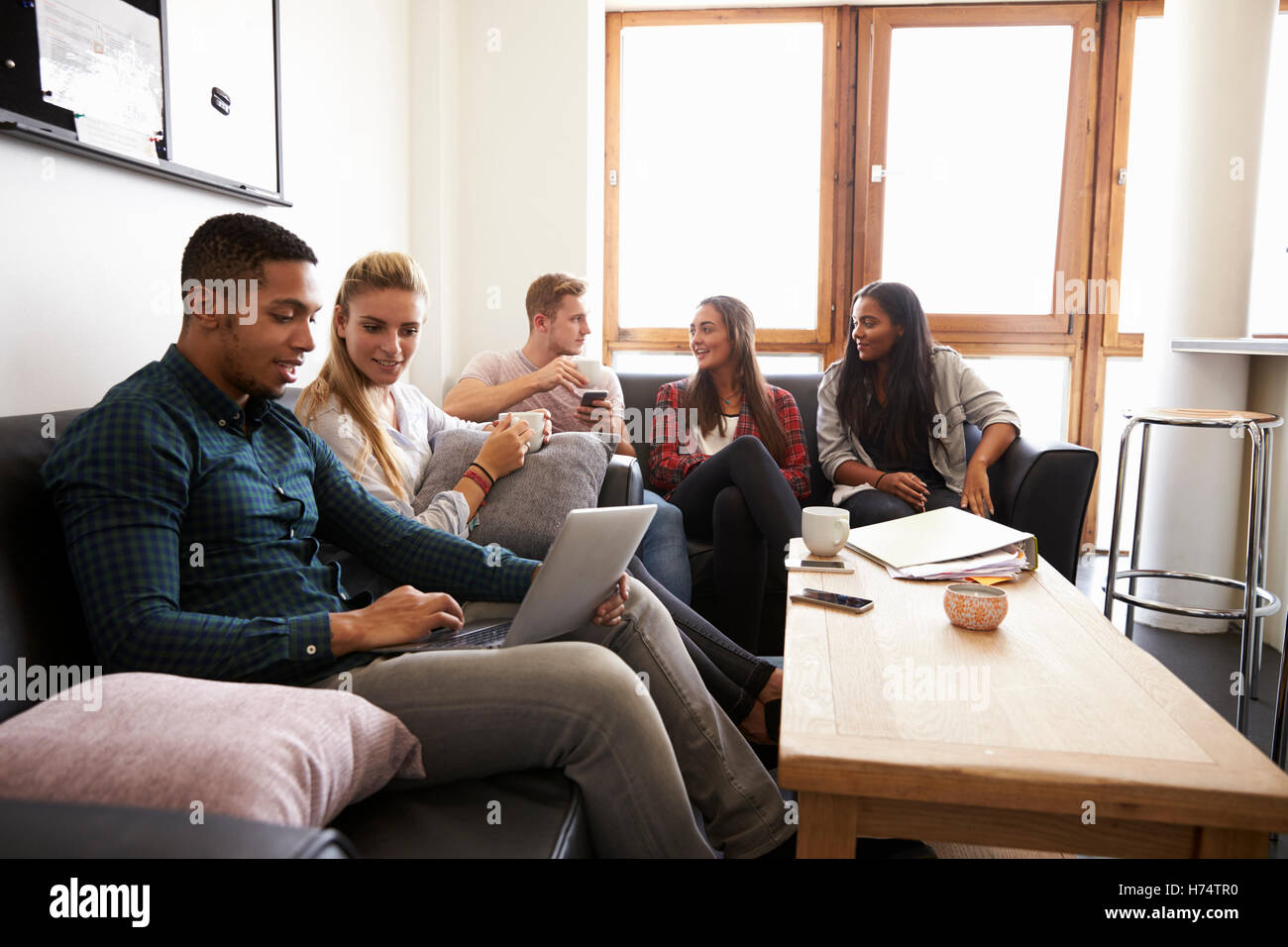 Students Relaxing In Lounge Of Shared Accommodation Stock Photo