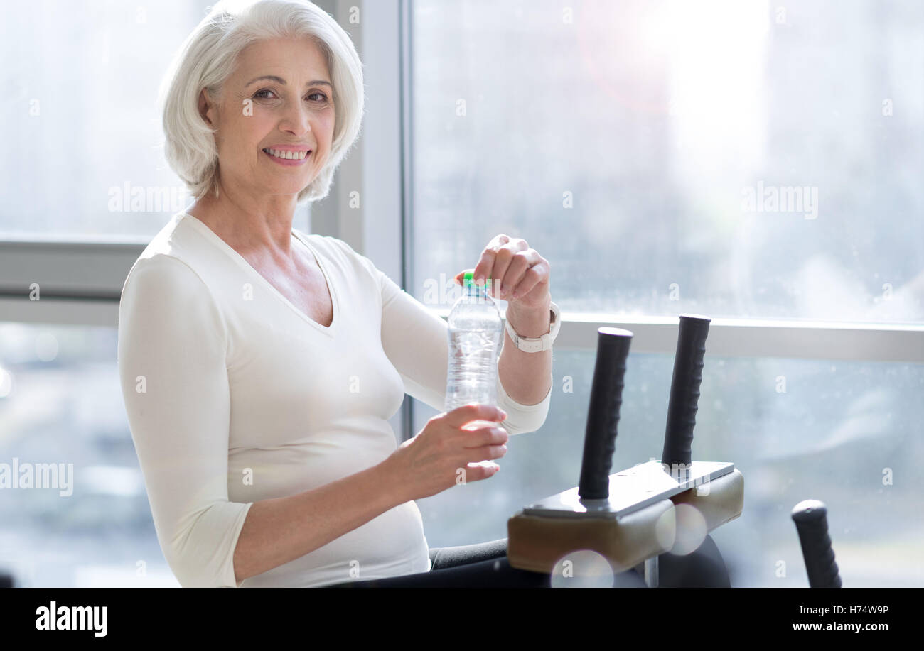 Joyful fit senior woman drinking water during workout Stock Photo Alamy