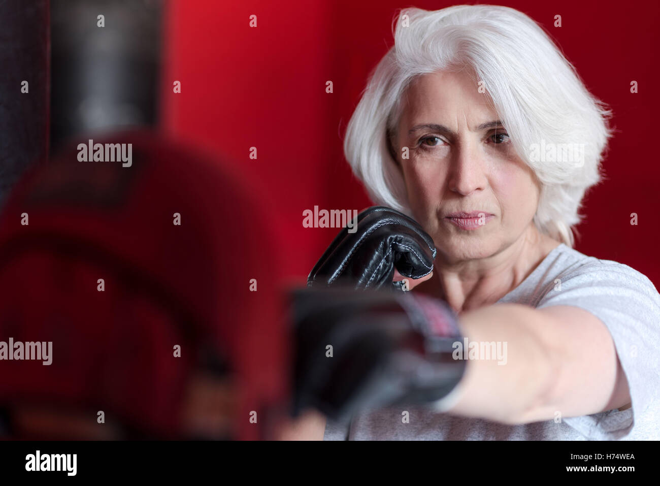 Pretty senior woman boxing punching bag Stock Photo Alamy