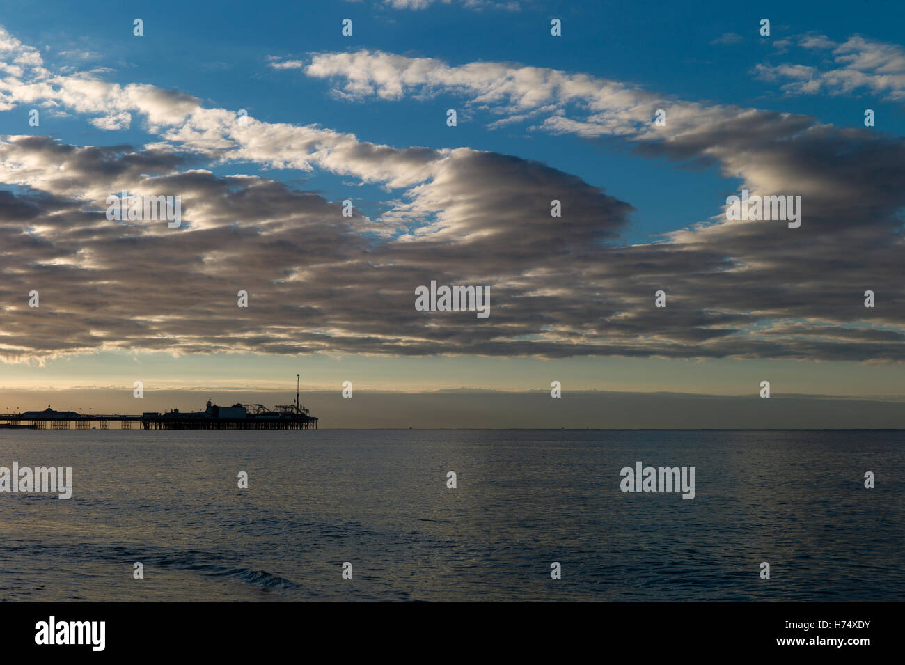Unusual curled cloud formation over silhouette of Brighton pier Stock Photo