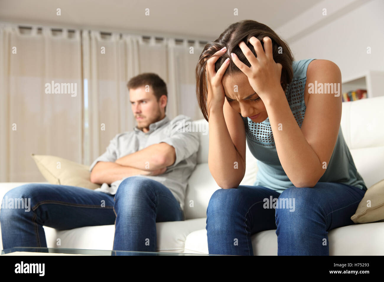 Angry boyfriend and sad girlfriend at home. Couple worried after argument Stock Photo