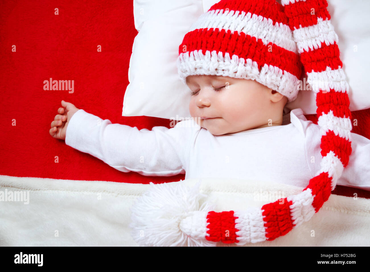 Sleepy baby on red blanket Stock Photo