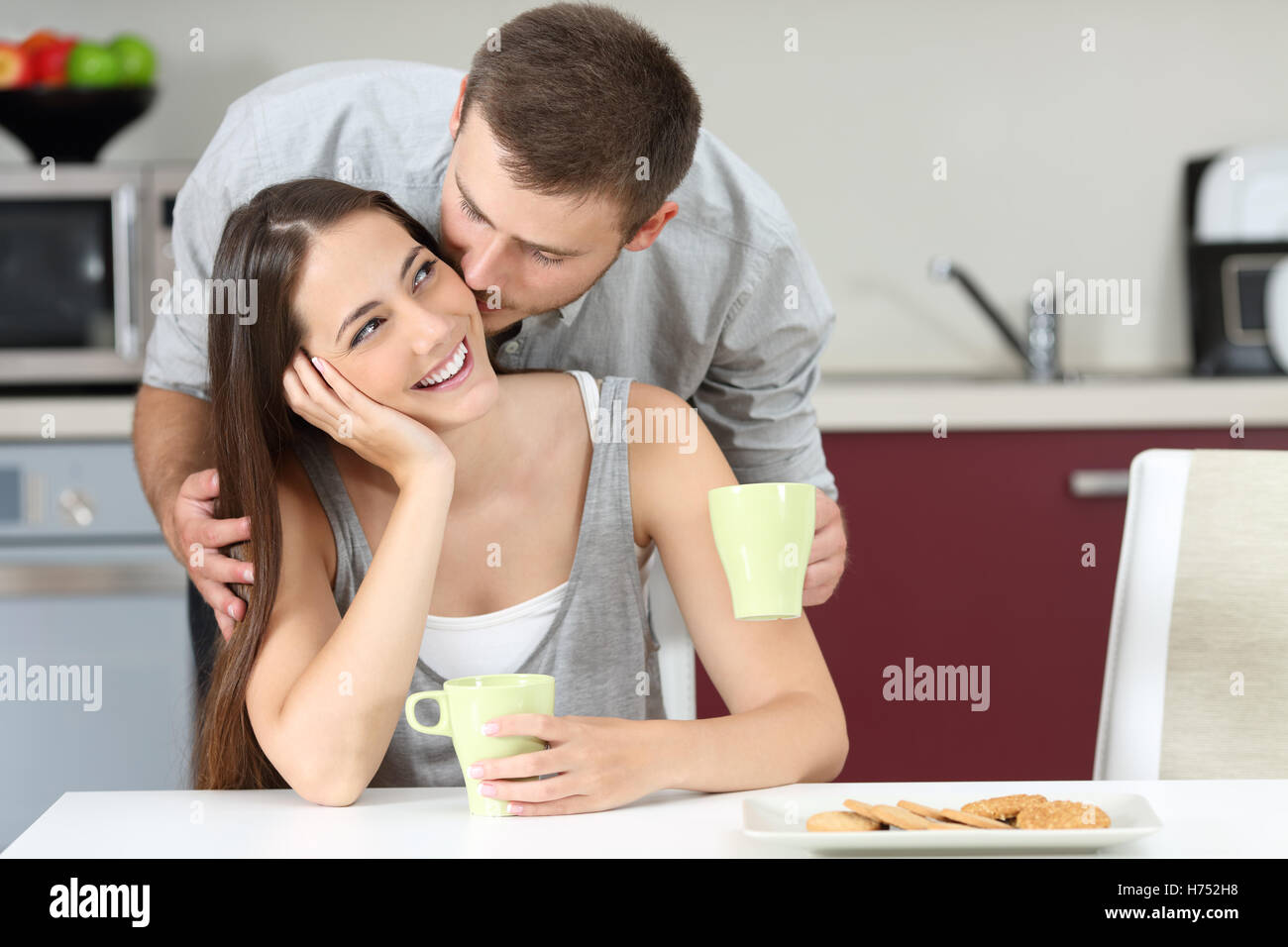 Happy husband kissing on cheek her wife at breakfast. Marriage life concept Stock Photo