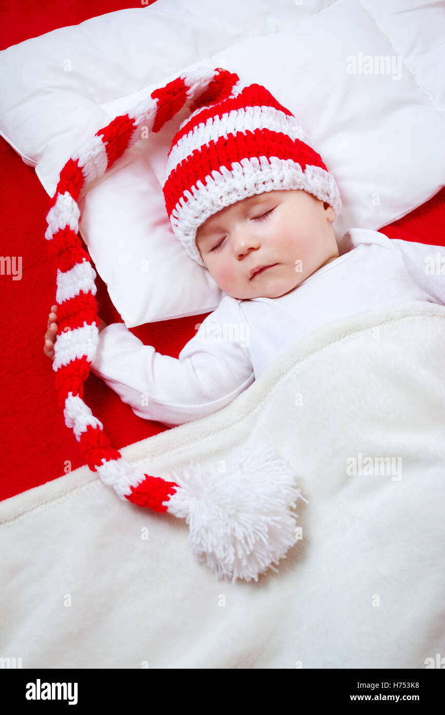 Sleepy baby on red blanket Stock Photo