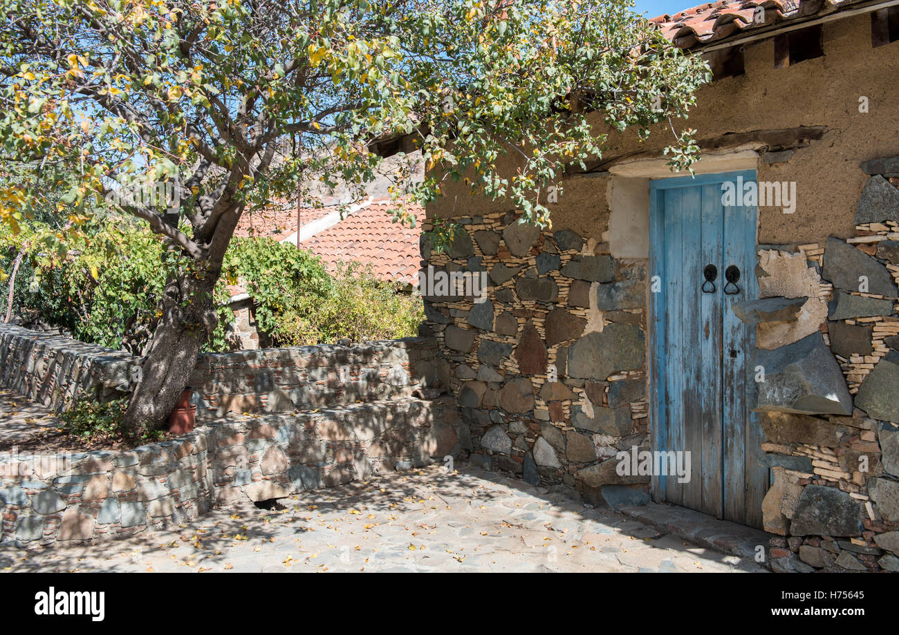 Traditional exterior yard of a house with a blue wooden door from a ...