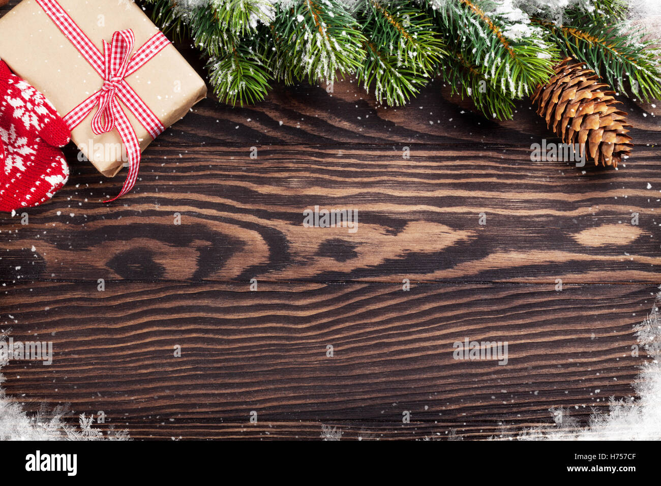 Christmas wooden background with snow fir tree, gift box and decoration ...