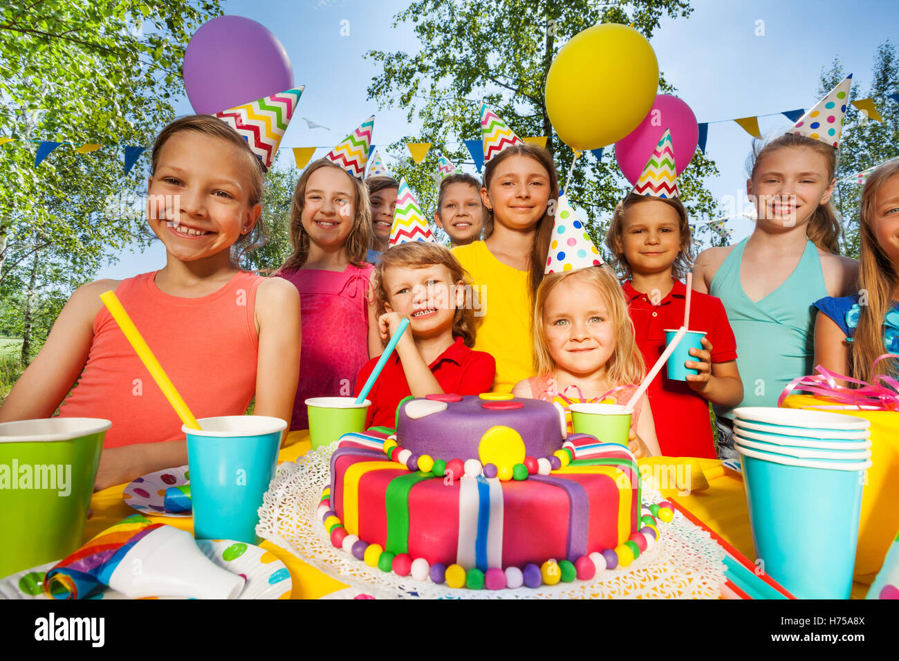 Big group of happy kids standing around B-day cake Stock Photo - Alamy