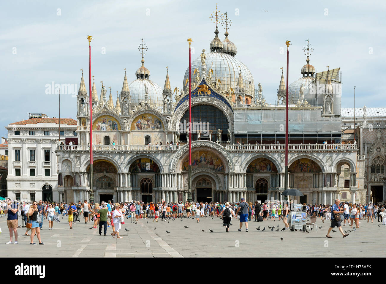 St. Mark’s square with tourists in front the St. Mark's Basilica of Venice in Italy. Stock Photo