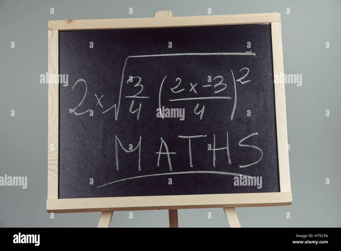 Math exercise written on the chalkboard. Gray background Stock Photo
