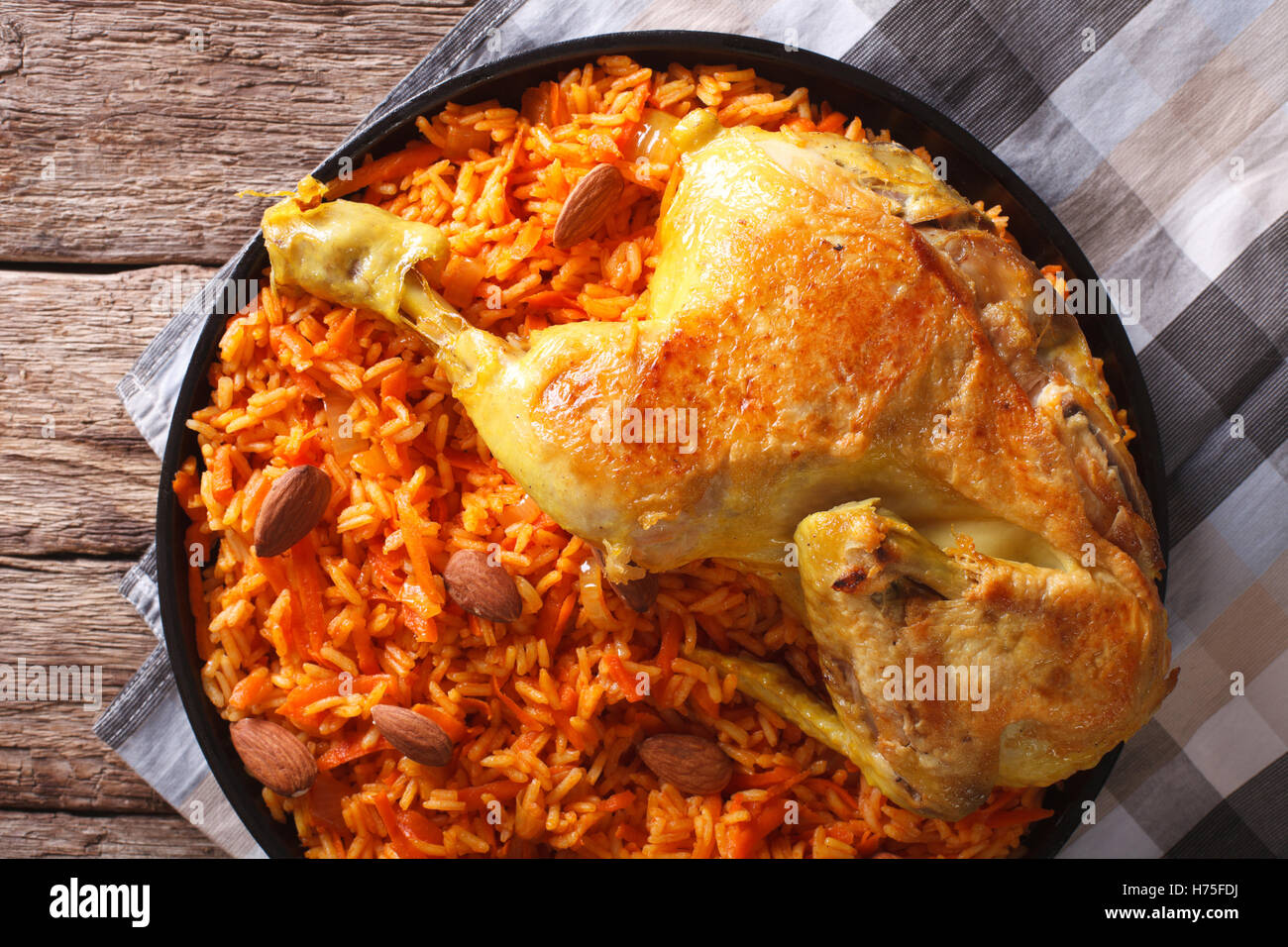 Kabsa spicy rice with vegetables and chicken on a plate closeup