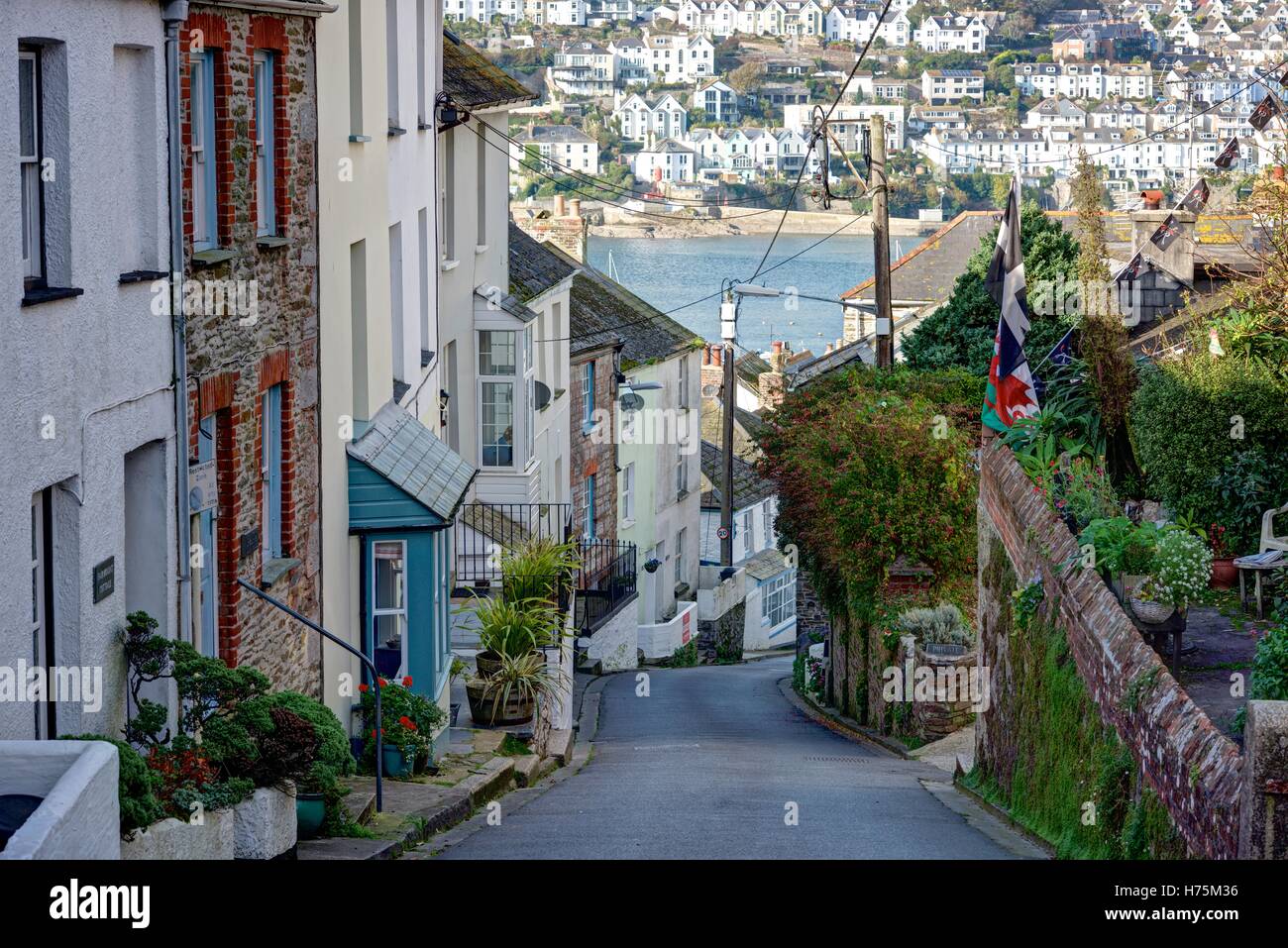 Cornwall's Polruan Village main street going down to the harbor showing the Fowey Estuary and Town in the distant background. Stock Photo