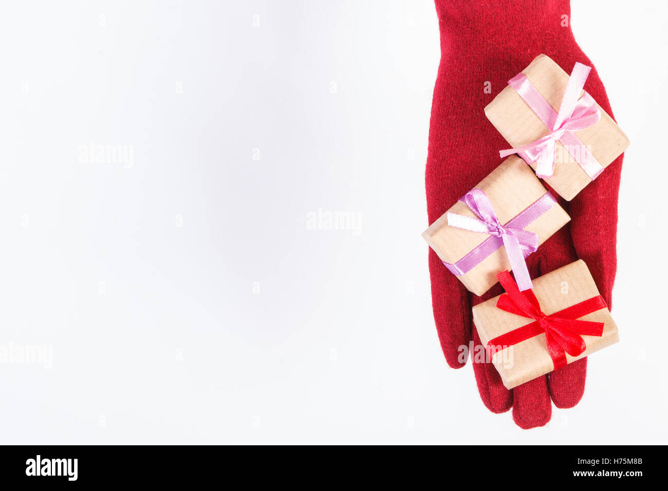 Hand of woman in red woolen gloves and wrapped gifts for Christmas ...