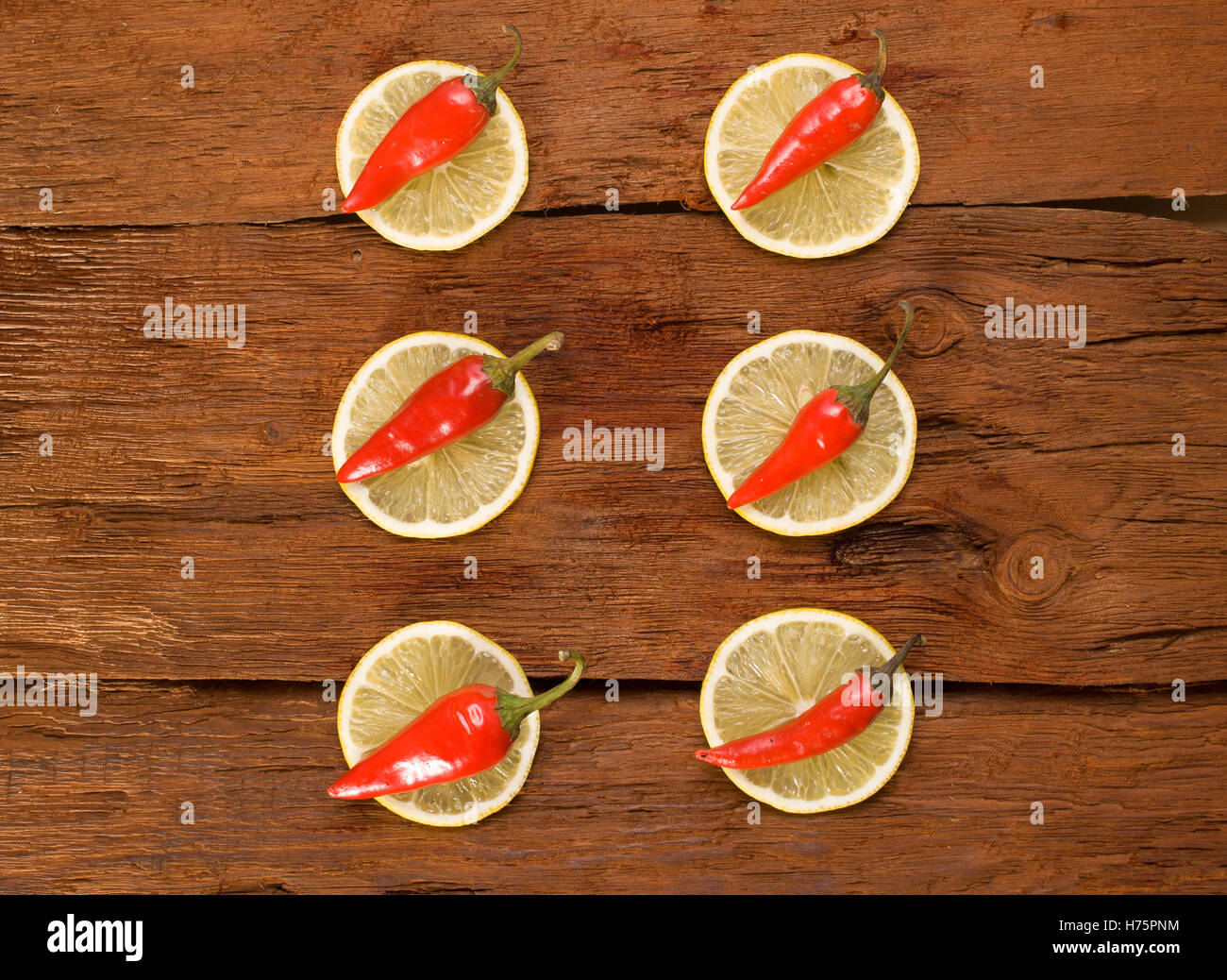 Red chili pepper, slices a lemon on brown cutting board Stock Photo - Alamy