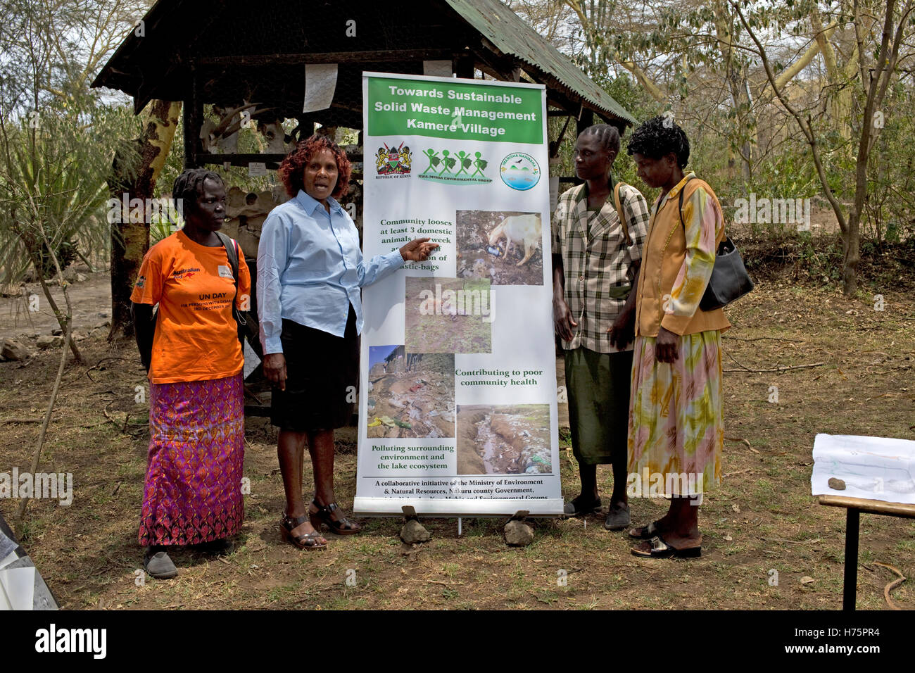 Four women with waste management poster Kamere Kenya Stock Photo