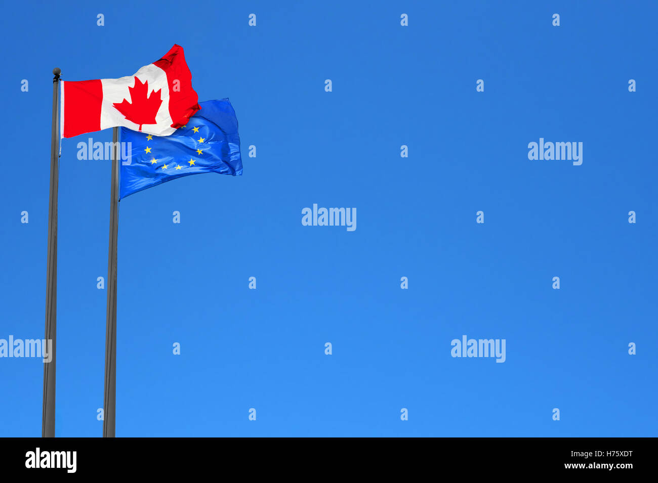 Canadian and European flags waving in the wind over blue sky (montage) Stock Photo