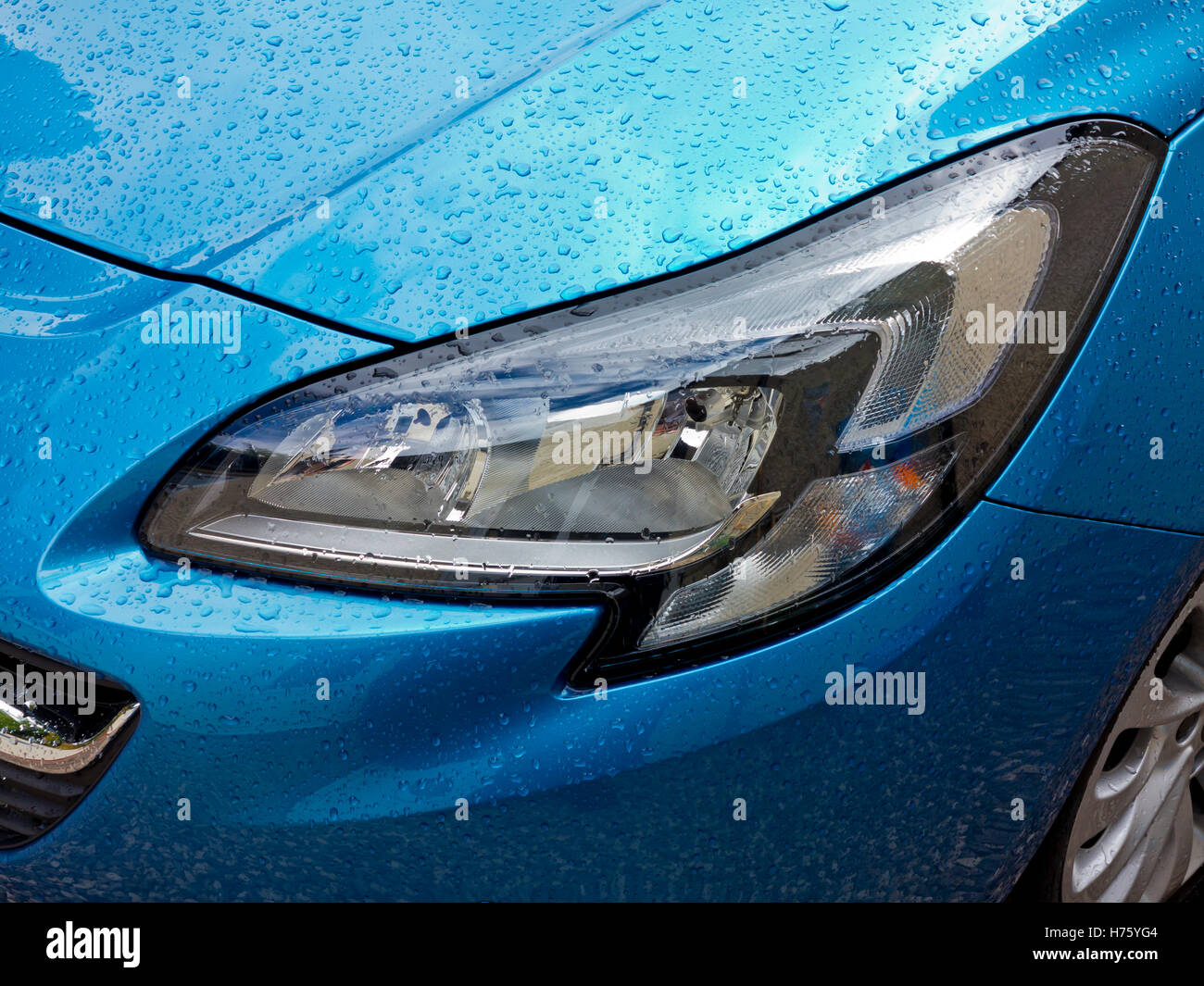 Close up view of metallic blue 2016 model Vauxhall Corsa car with water  drops on body and headlights Stock Photo - Alamy