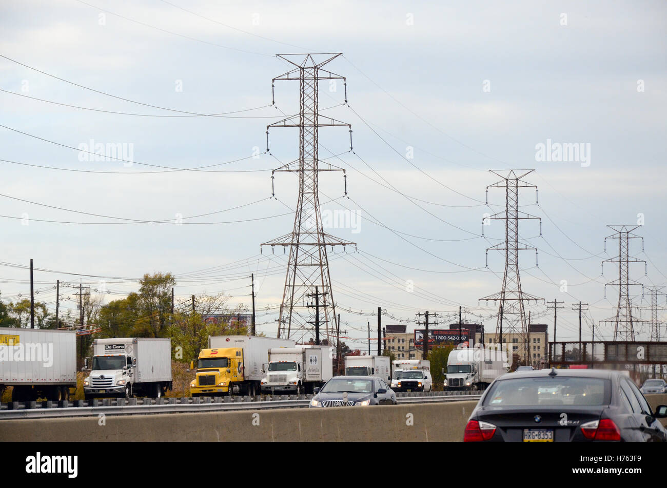 High voltage power lines along a highway filled with semitrailer