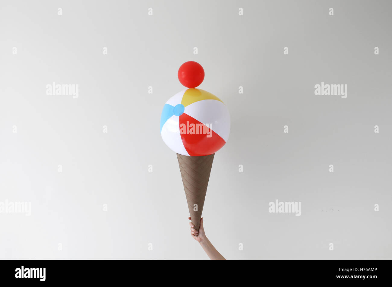 Conceptual Hand holding giant ice-cream cone Stock Photo