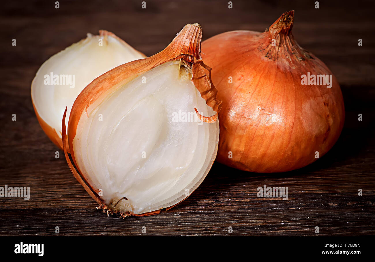 Wholly onion and two halves on a wooden table Stock Photo