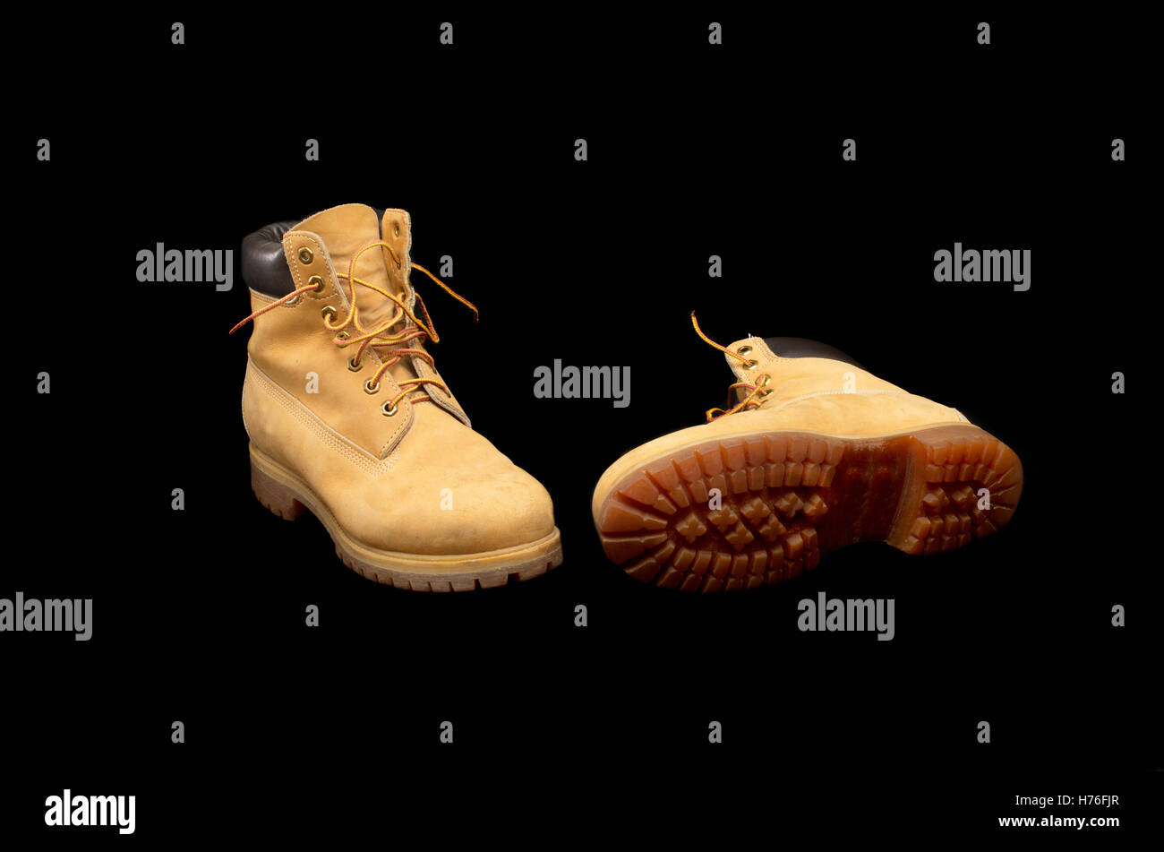 Authentic pair of 8 inch Yellow Work Boots isolated on black showing the sole Stock Photo