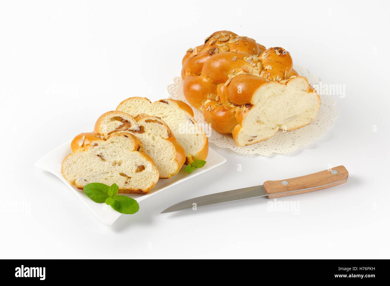 sliced loaf of sweet braided bread with almonds and raisins Stock Photo