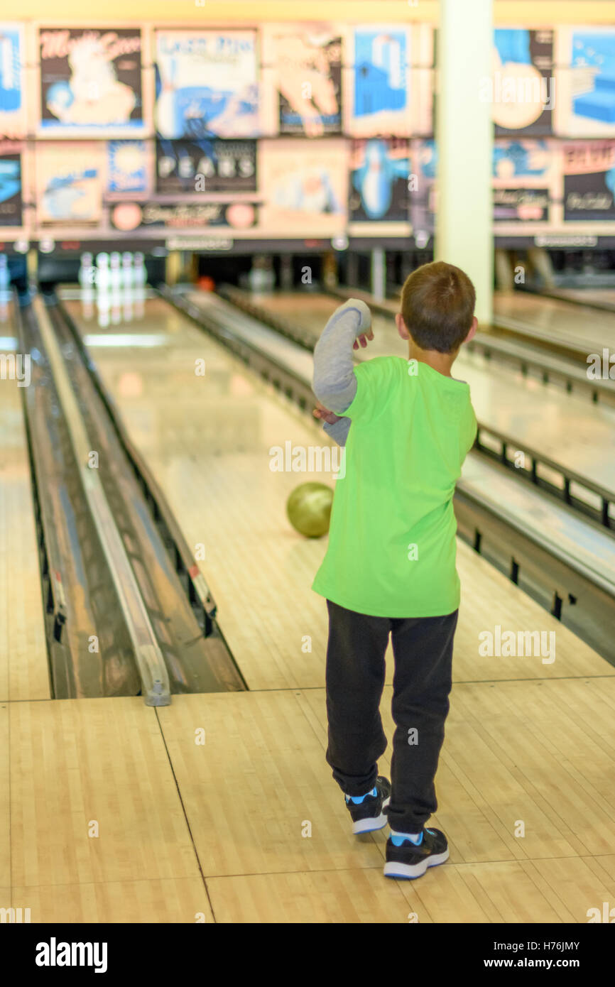 An 8 year old boy enjoying a game of bowling in a retro style bowling alley  near Tel Aviv, Israel featuring old-time bowling add Stock Photo - Alamy