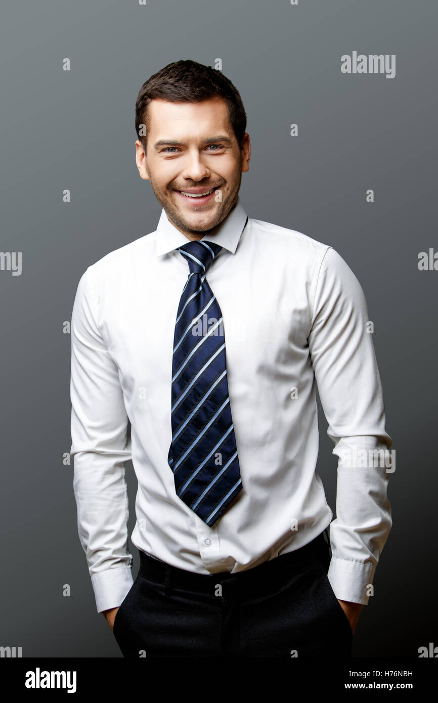 Handsome stylish businessman on grey background Stock Photo - Alamy