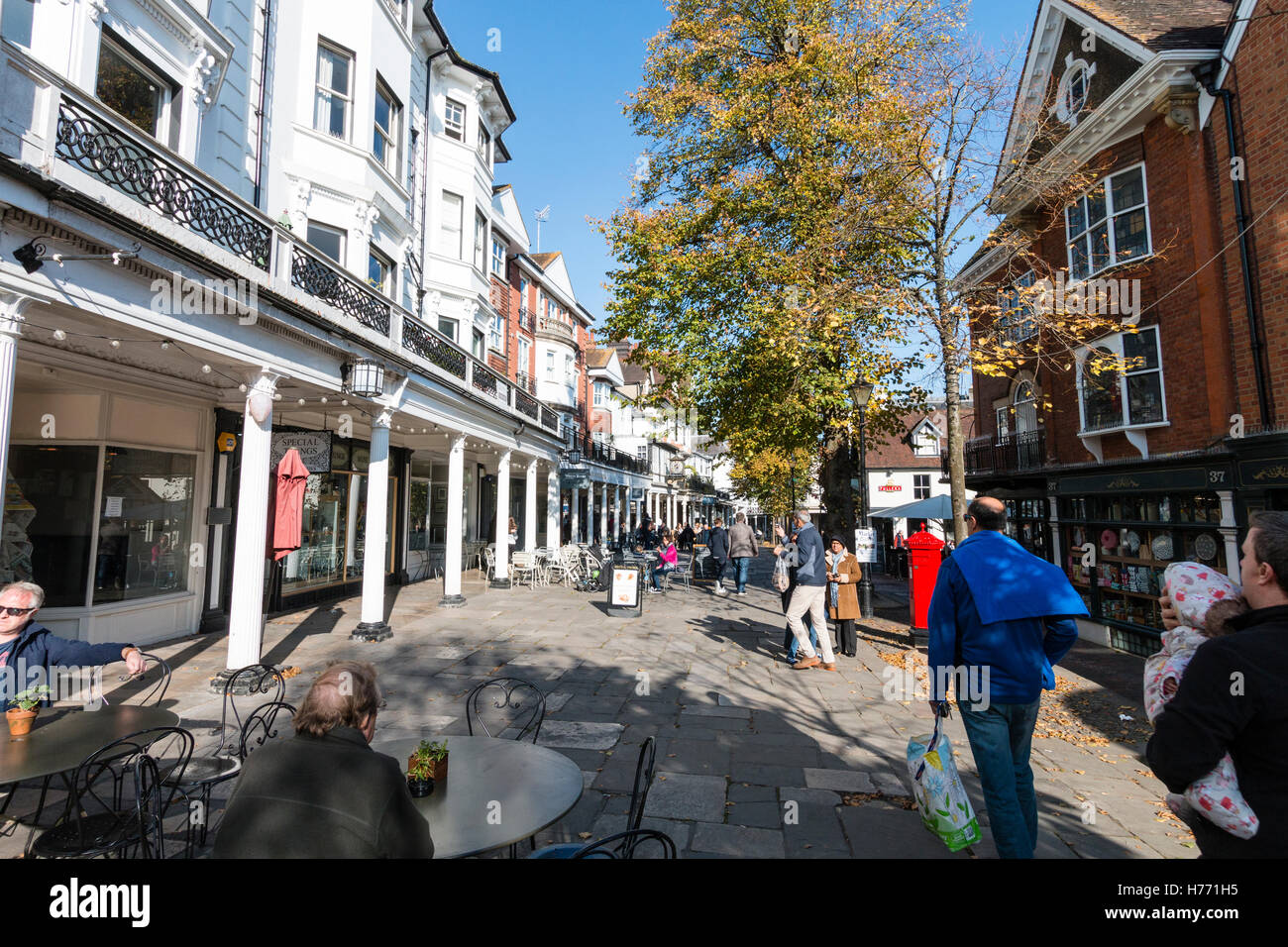 England, Tunbridge Wells. View along the famous Pantiles in the autumn. White fronted shops and stores with people. Bright sunshine. Stock Photo