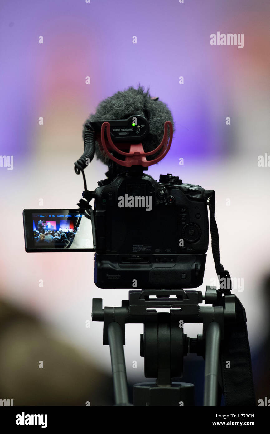 A digital slr video camera on a tripod with microphone recording video at an event Stock Photo