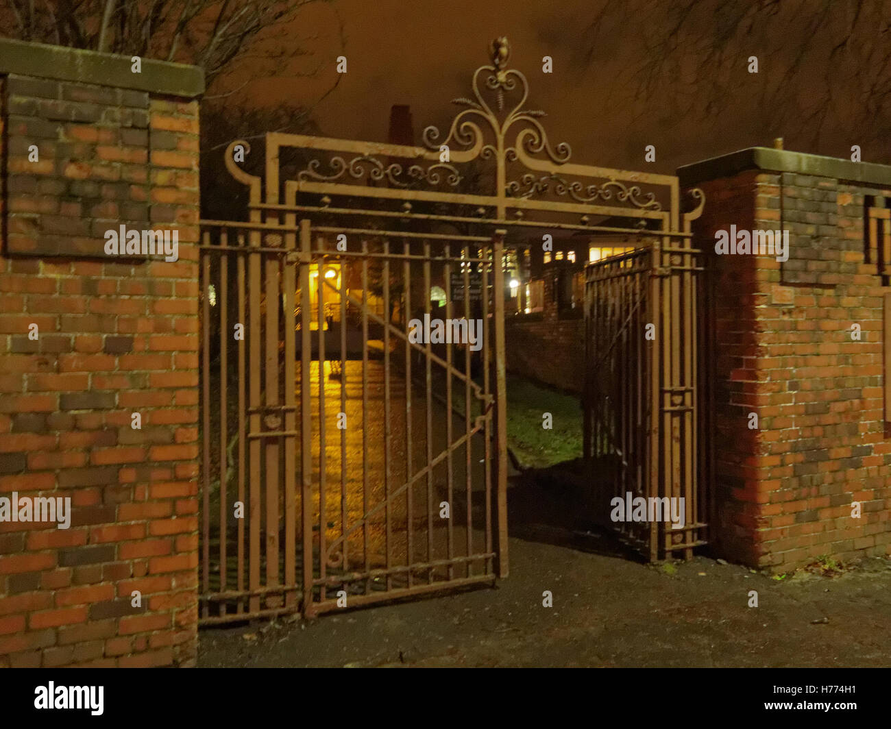 Old iron gate open and spooky or scary at night Stock Photo
