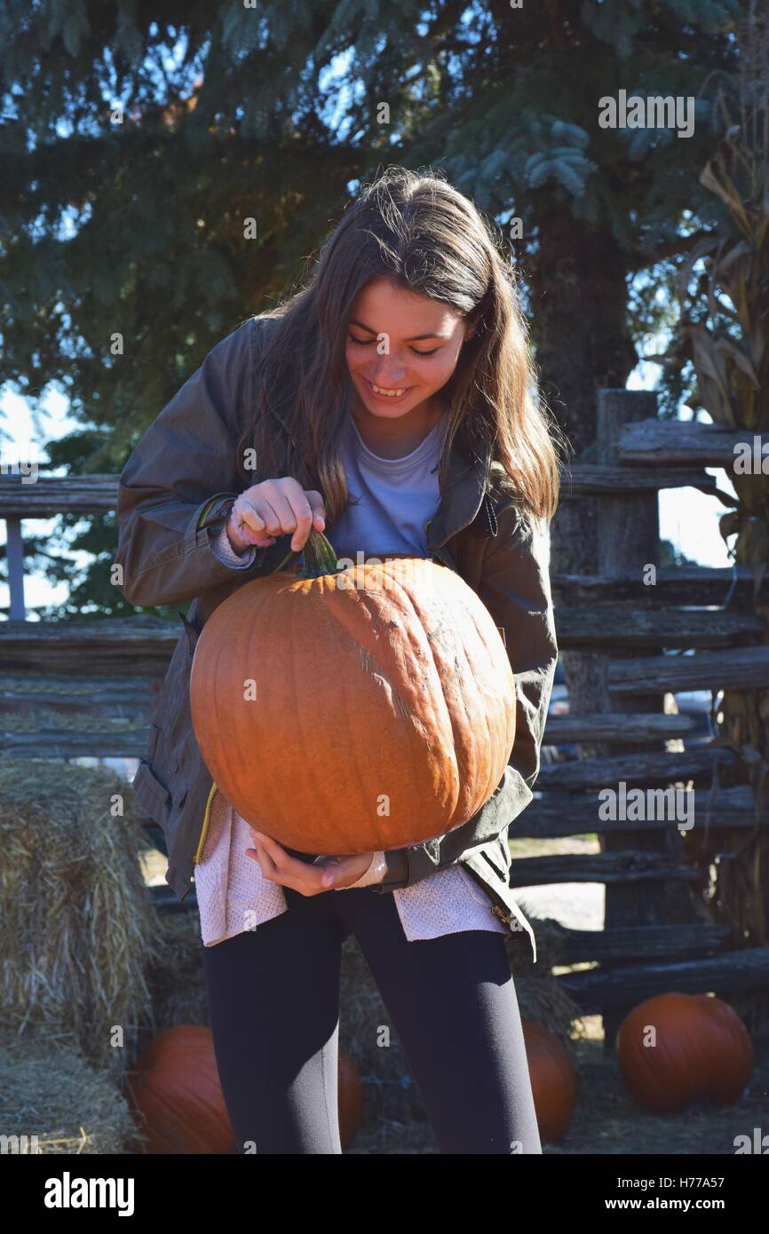 Girl lifting a pumpkin Stock Photo - Alamy